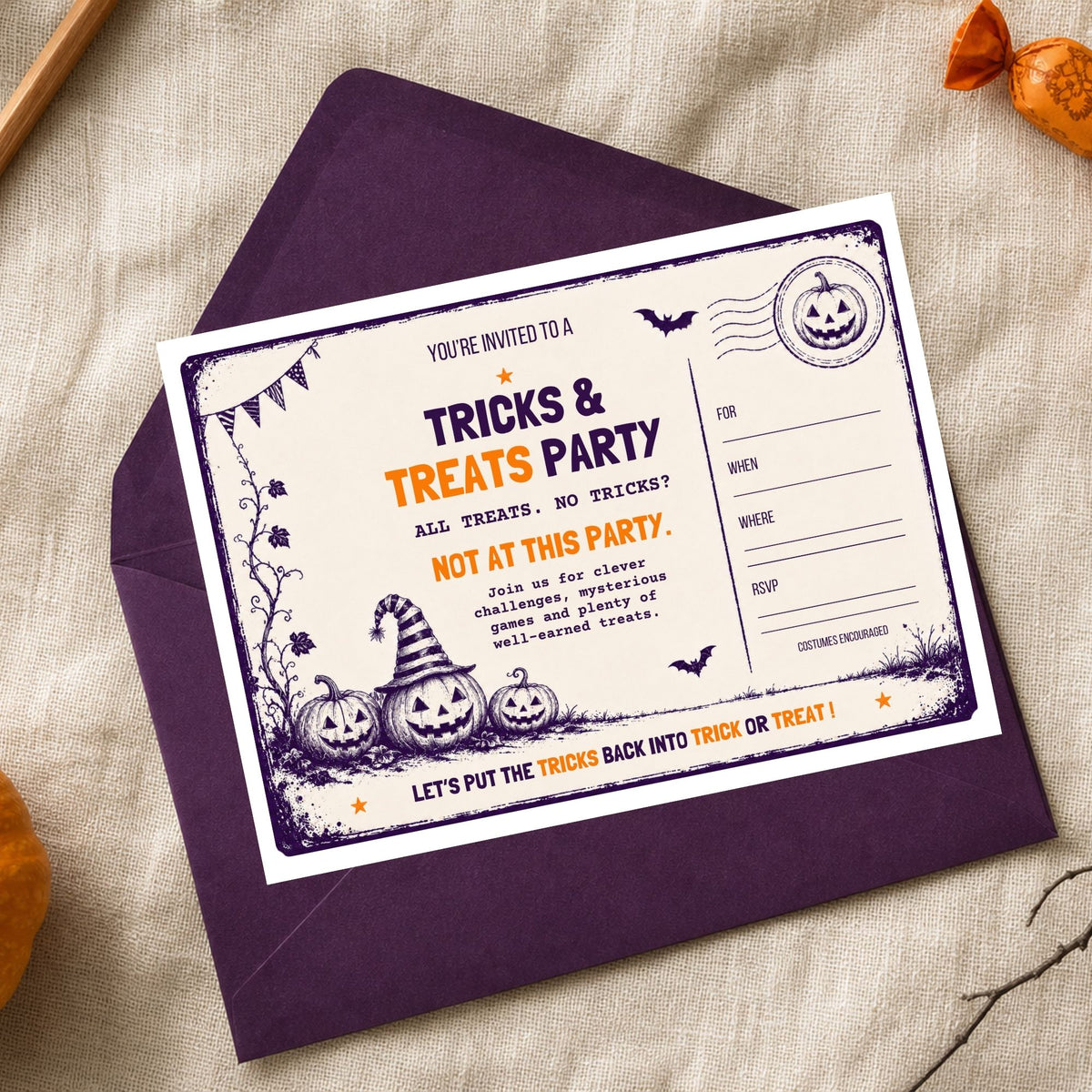 A Halloween-themed invitation card for a 'Tricks & Treats Party' displayed on top of a dark purple envelope, set against a textured beige linen background with small orange pumpkin decorations.