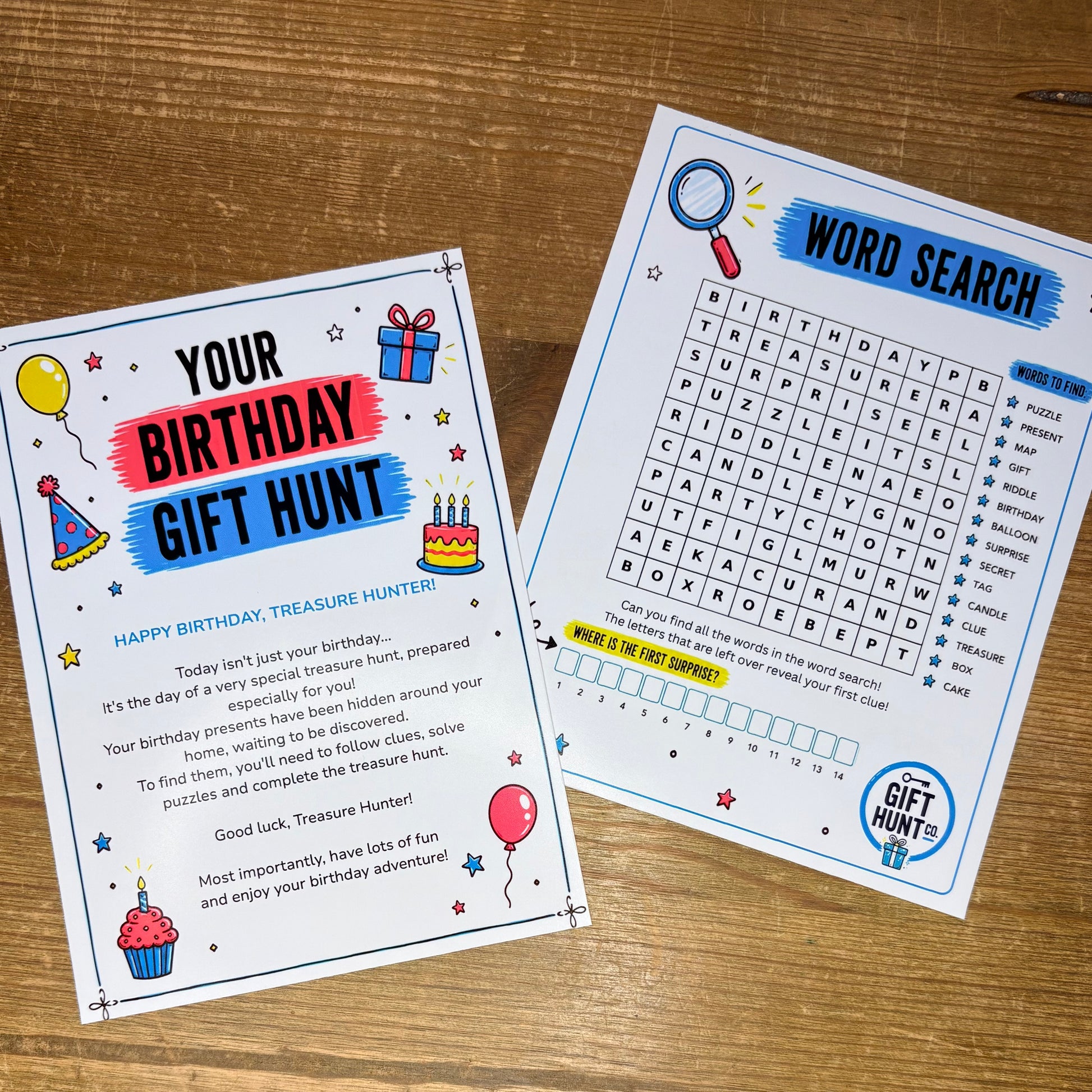 Two printed activity cards for a birthday treasure hunt game, shown on a wooden tabletop. One card reads 'YOUR BIRTHDAY GIFT HUNT' with birthday-themed illustrations, and the other shows a 'WORD SEARCH' grid with a 'TREASURE HUNT' logo.