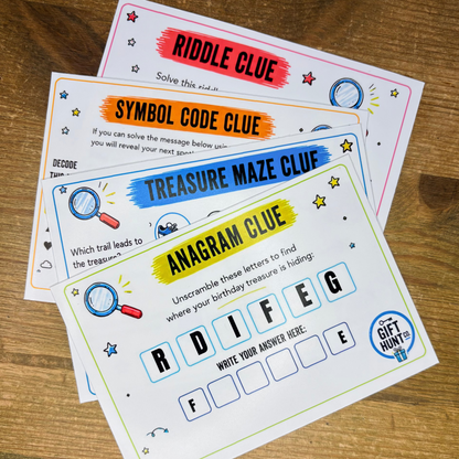 Four printable game cards for a treasure hunt, including 'Riddle Clue', 'Symbol Code Clue', 'Treasure Maze Clue', and 'Anagram Clue', arranged in a fan shape on a wooden tabletop.